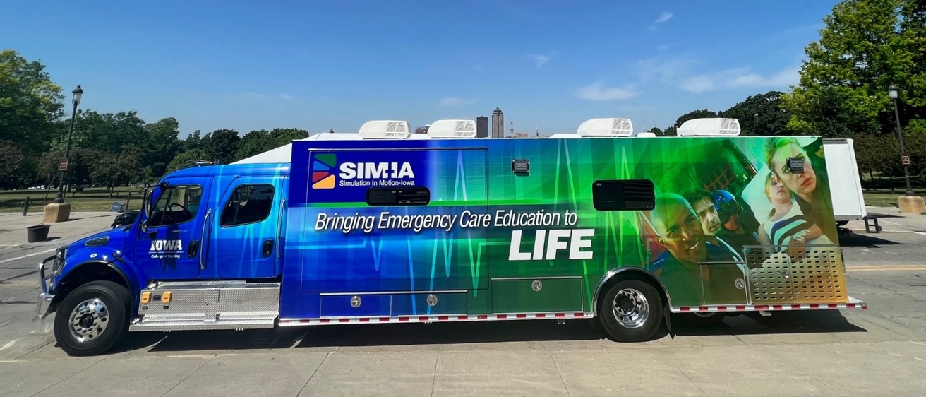 Photo of the SIM-IA mobile simulation truck - a large, semi-like vehicle with a blue cab. 