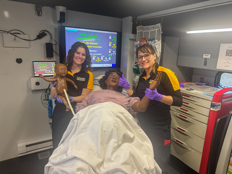 SIM-IA educators pose with female patient simulator