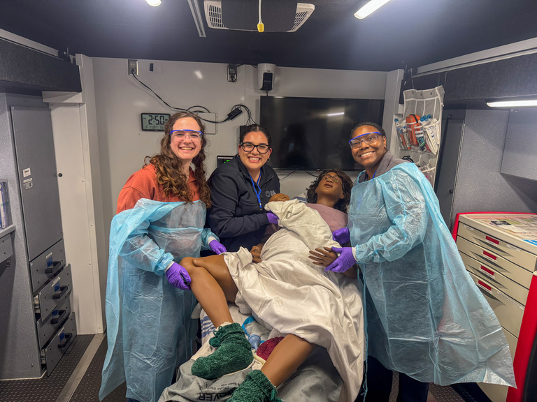 Simulation participants pose with female mannequin