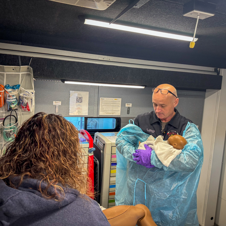 Fire professional holding infant patient simulator