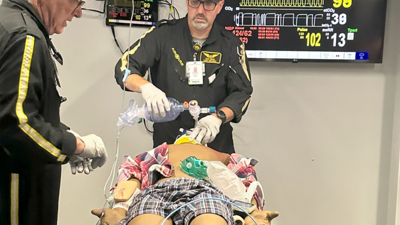 Two healthcare professionals with a manikin